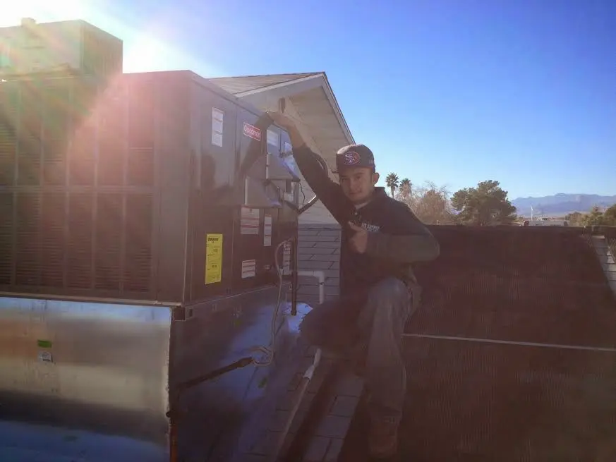 HVAC technician performing Boiler Repair on a rooftop unit in Bridge City